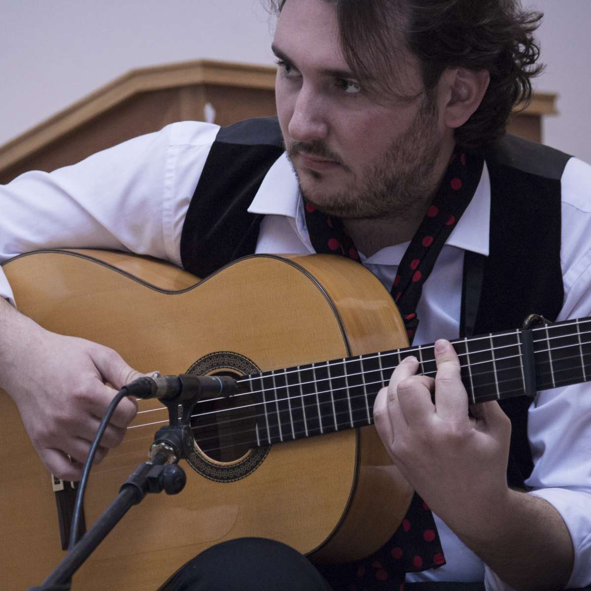 Flamenco guitarist José Tomás Jiménez confidently playing without looking at the strings
