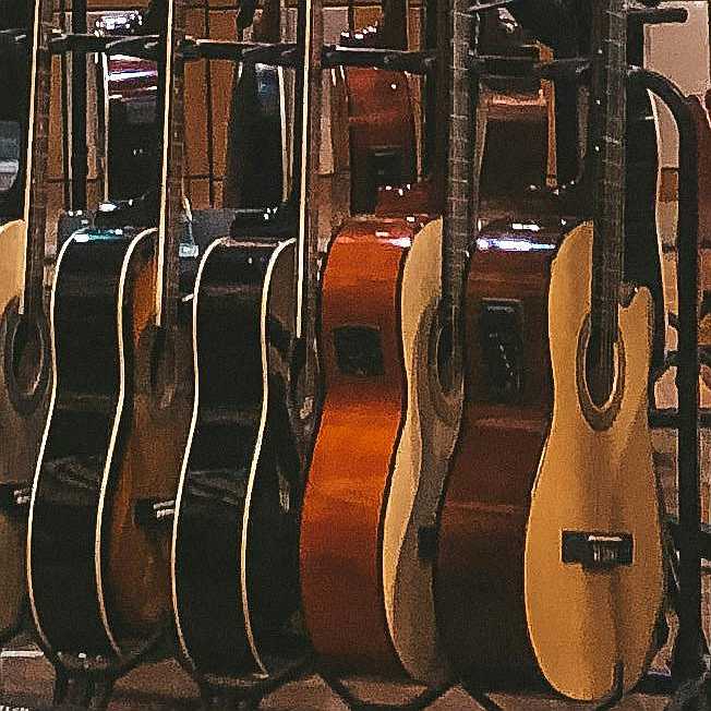 A collection of nylon string guitars at the music store which are perfect for fingerstyle guitar playing