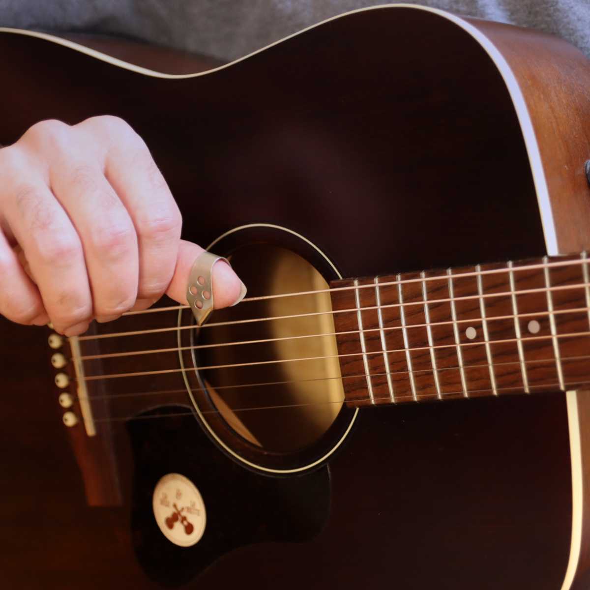 Brett demonstrating the thumb pick on an acoustic guitar